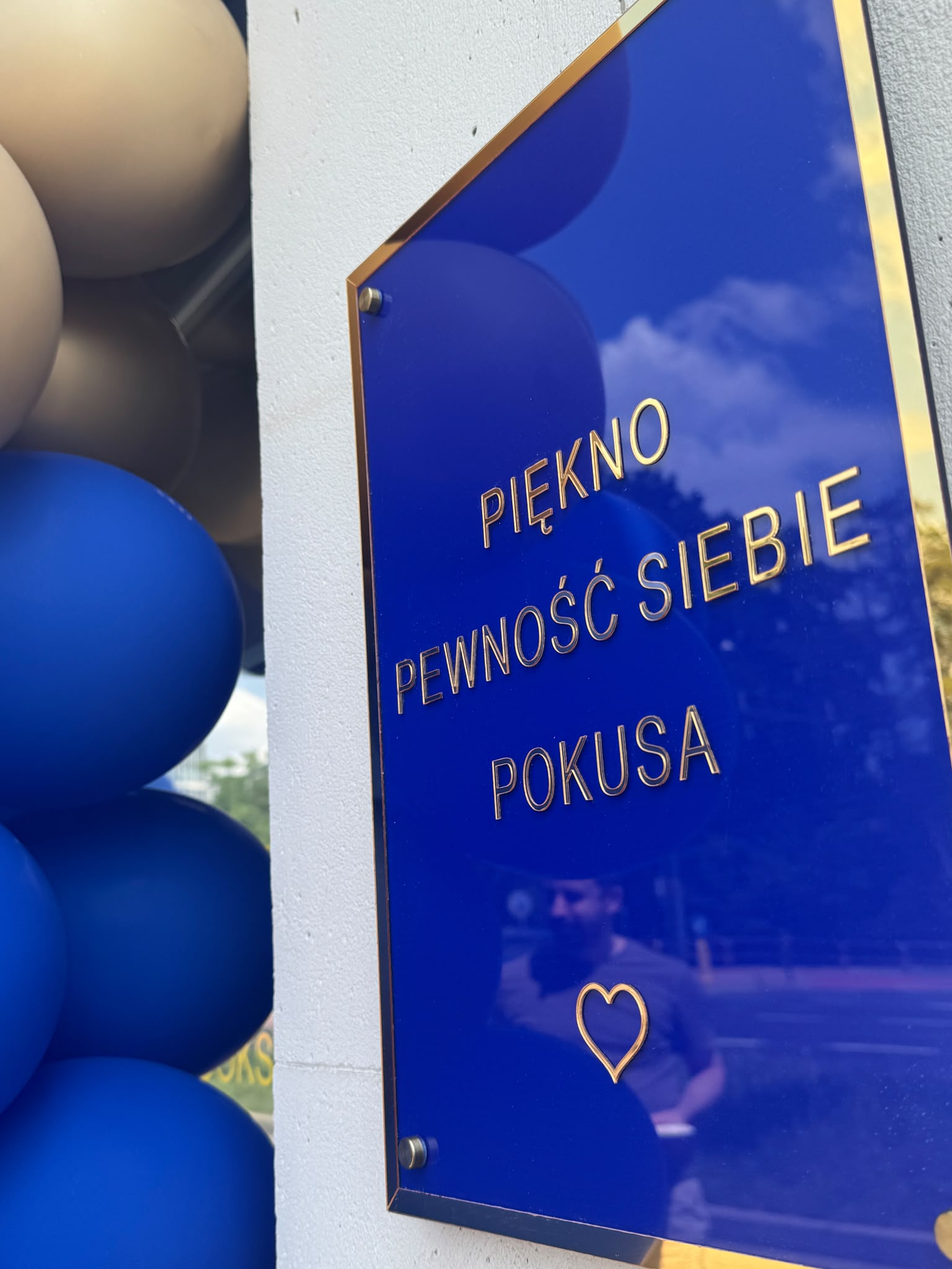 Wejście i granatowo-złoty szyld Pokusa Beauty Studio przy al. 29 Listopada 81/3 w Krakowie